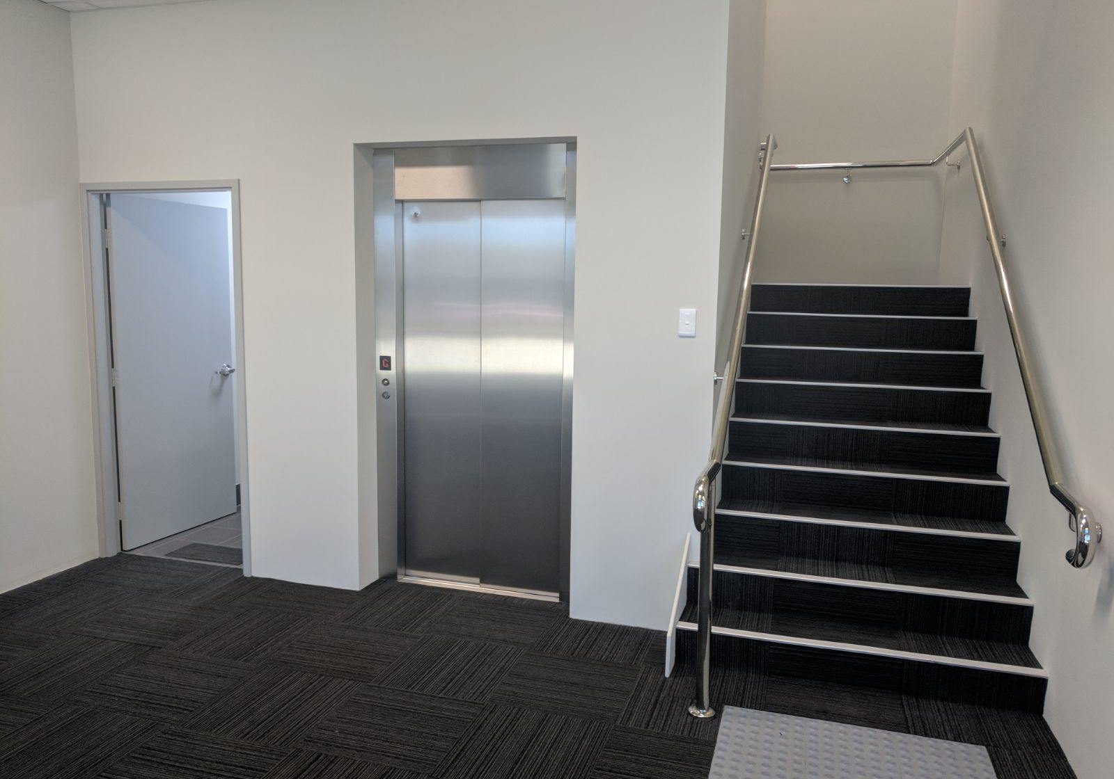 Closed doors of a commercial elevator next to the stairs